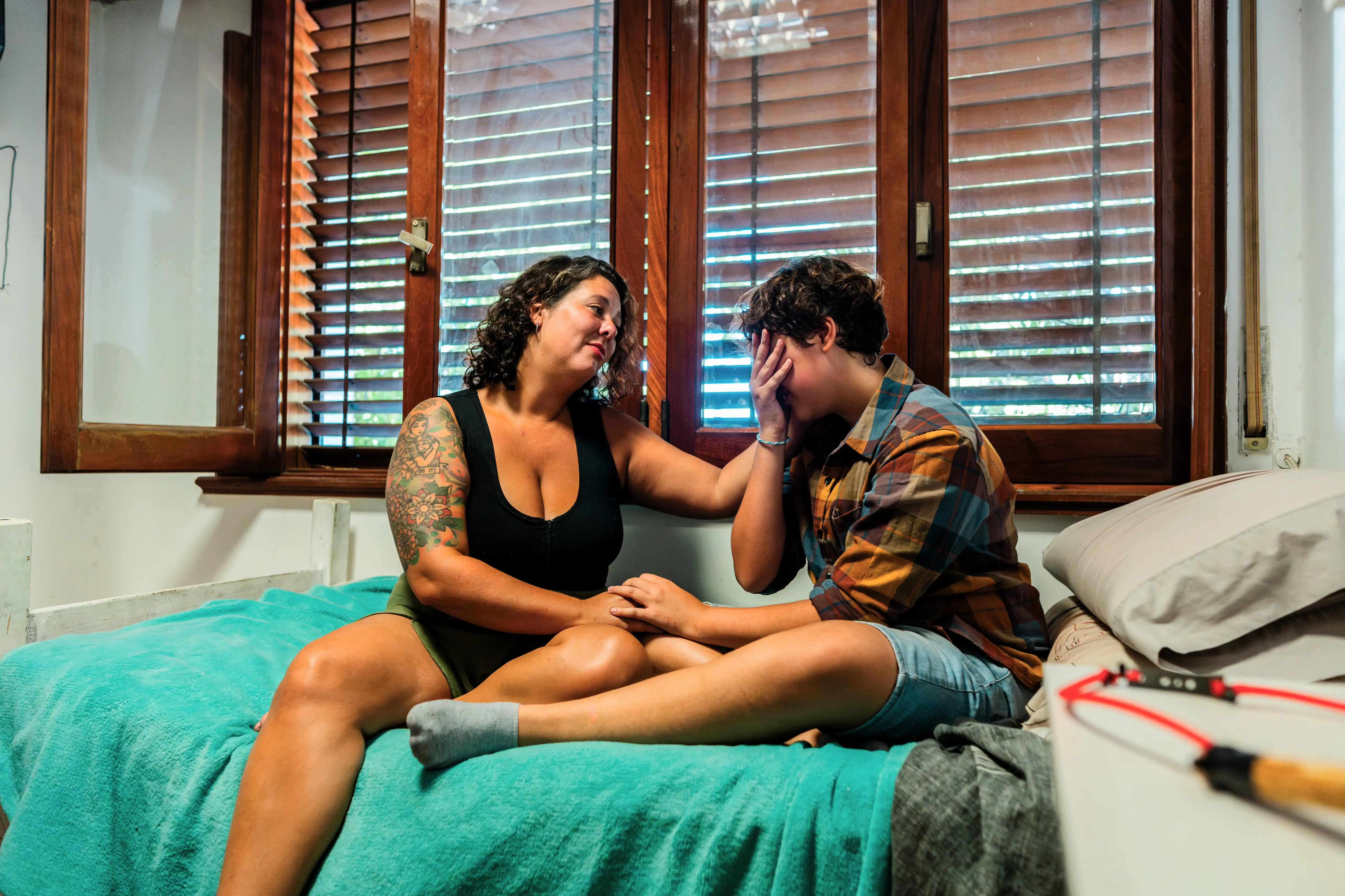 A mother consoling her transgender son at home