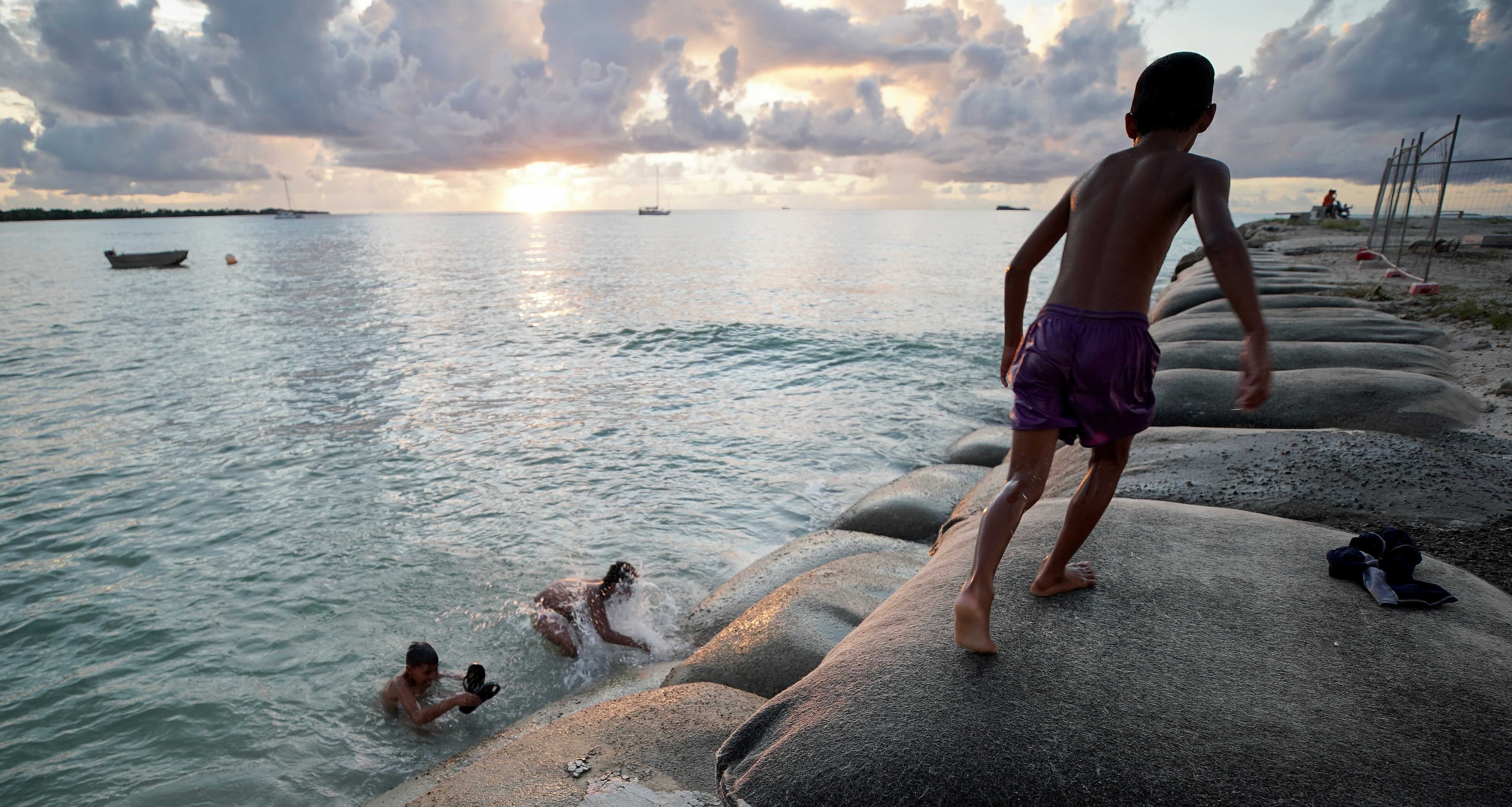 Boys playing on sandbags Tuvalu