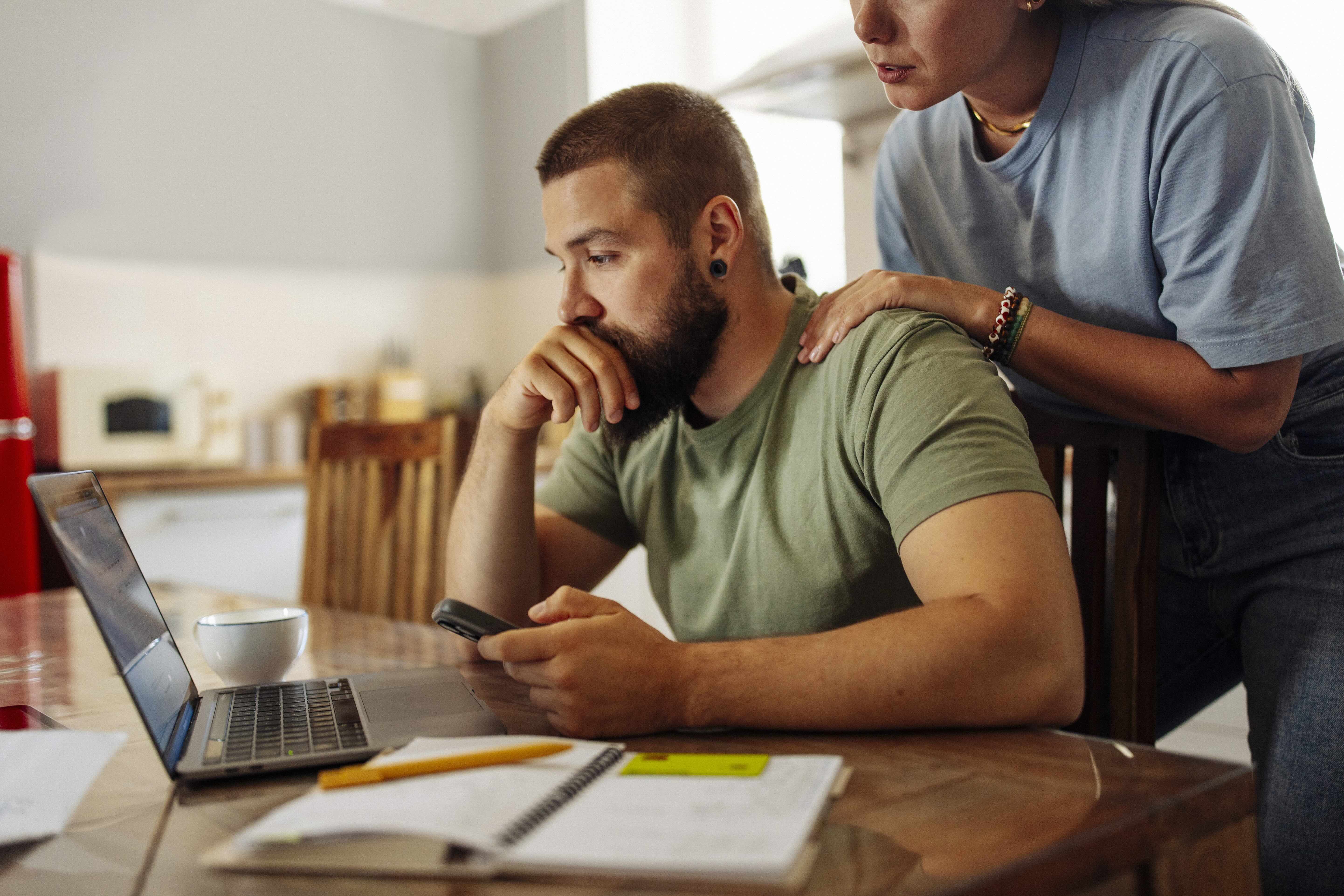Couple looking at bills on laptop